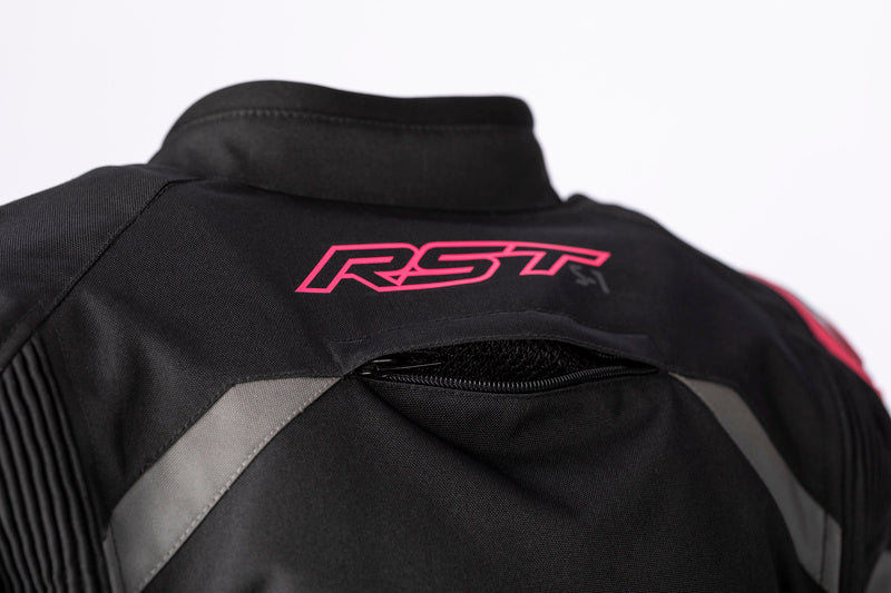 Närbild på RST-logotypen i rosa på ryggen av RST Dam Textil Mc-Jacka S-1, med ventilationsdetaljer för komfort.